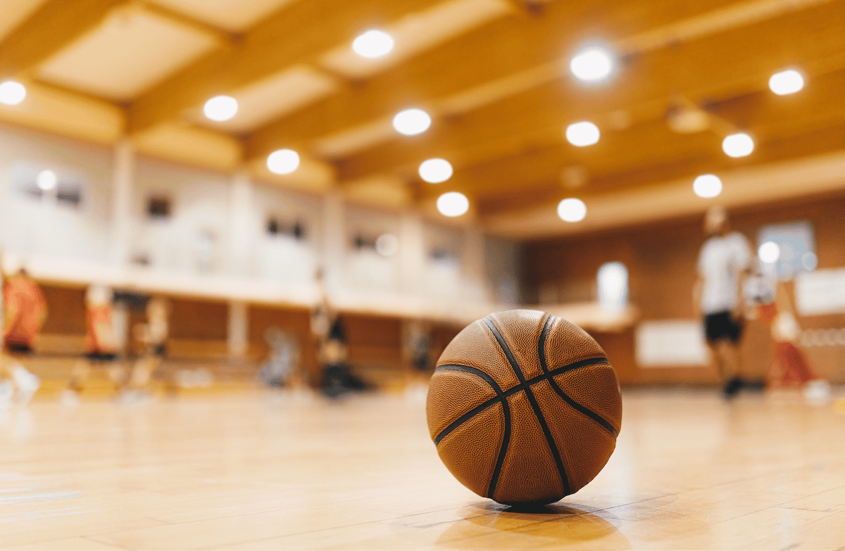 Basketball on wooden court during recovery support group session.