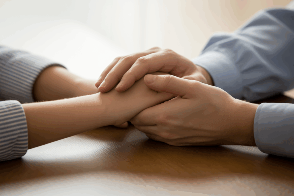 Supportive hands holding during addiction recovery at Red Ribbon Recovery Indiana, emphasizing compassion and healing.