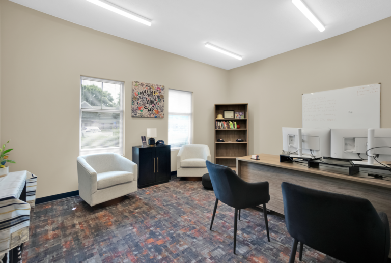 Comfortable recovery center office with seating, computers, and motivational decor for addiction treatment.