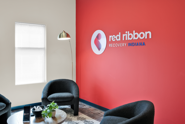 Comfortable recovery center waiting area with Red Ribbon Recovery Indiana branding.