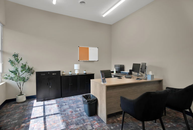 Comfortable, organized addiction recovery office with desks, chairs, and recovery resources.