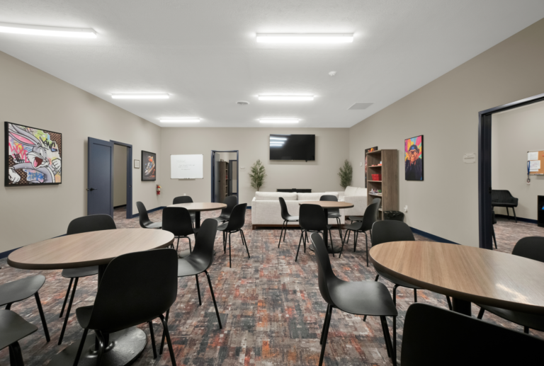 Bright, welcoming rehab recovery lounge with seating and therapeutic art at Red Ribbon Recovery Indiana.