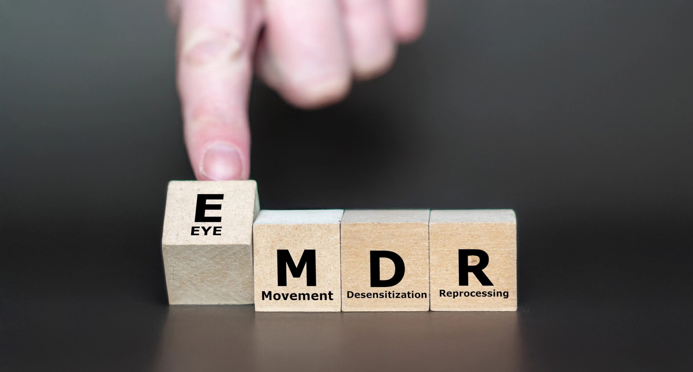 Substance abuse recovery concept with wooden blocks spelling EMD for Eye Movement Desensitization and Reprocessing (EMDR) therapy.