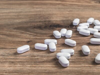 Pills scattered on wooden surface, representing opioid medication and overdose risks.