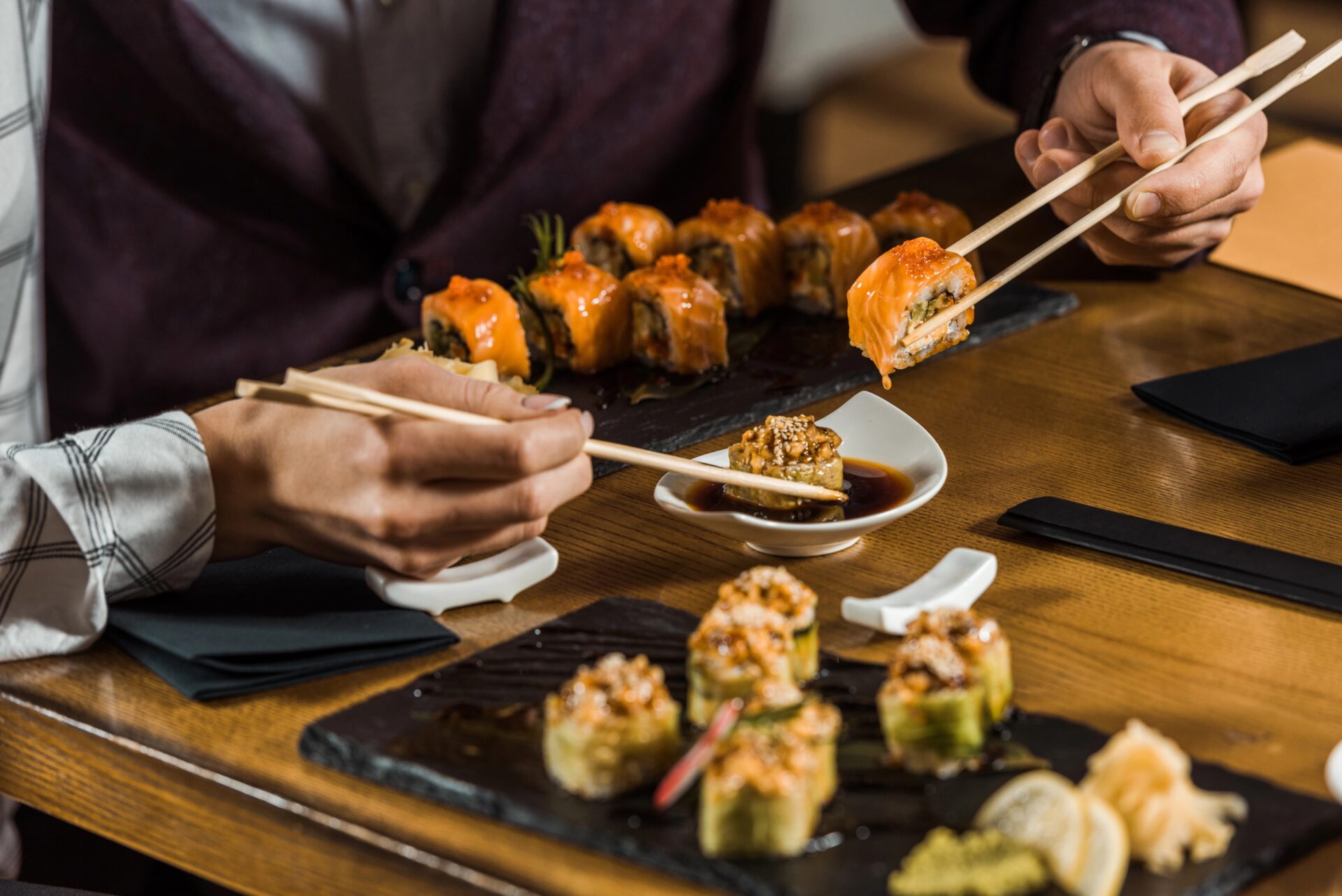 People enjoying sushi at a restaurant, showcasing Japanese cuisine.