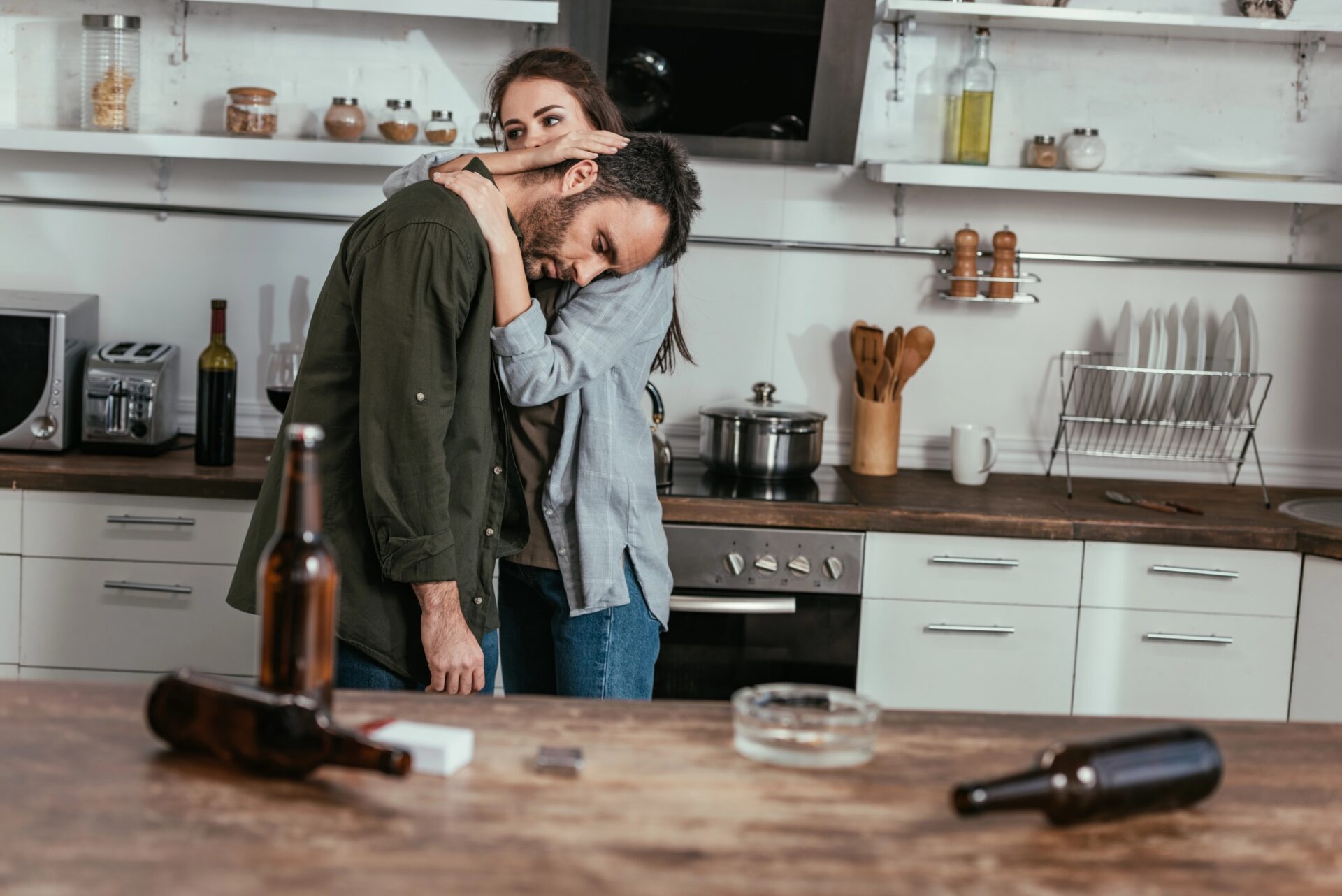 Supportive couple in kitchen after substance recovery.