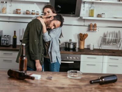 Supportive couple in kitchen after substance recovery.