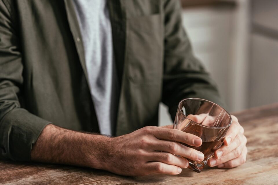 Supportive person holding a glass of water, promoting sobriety and recovery.