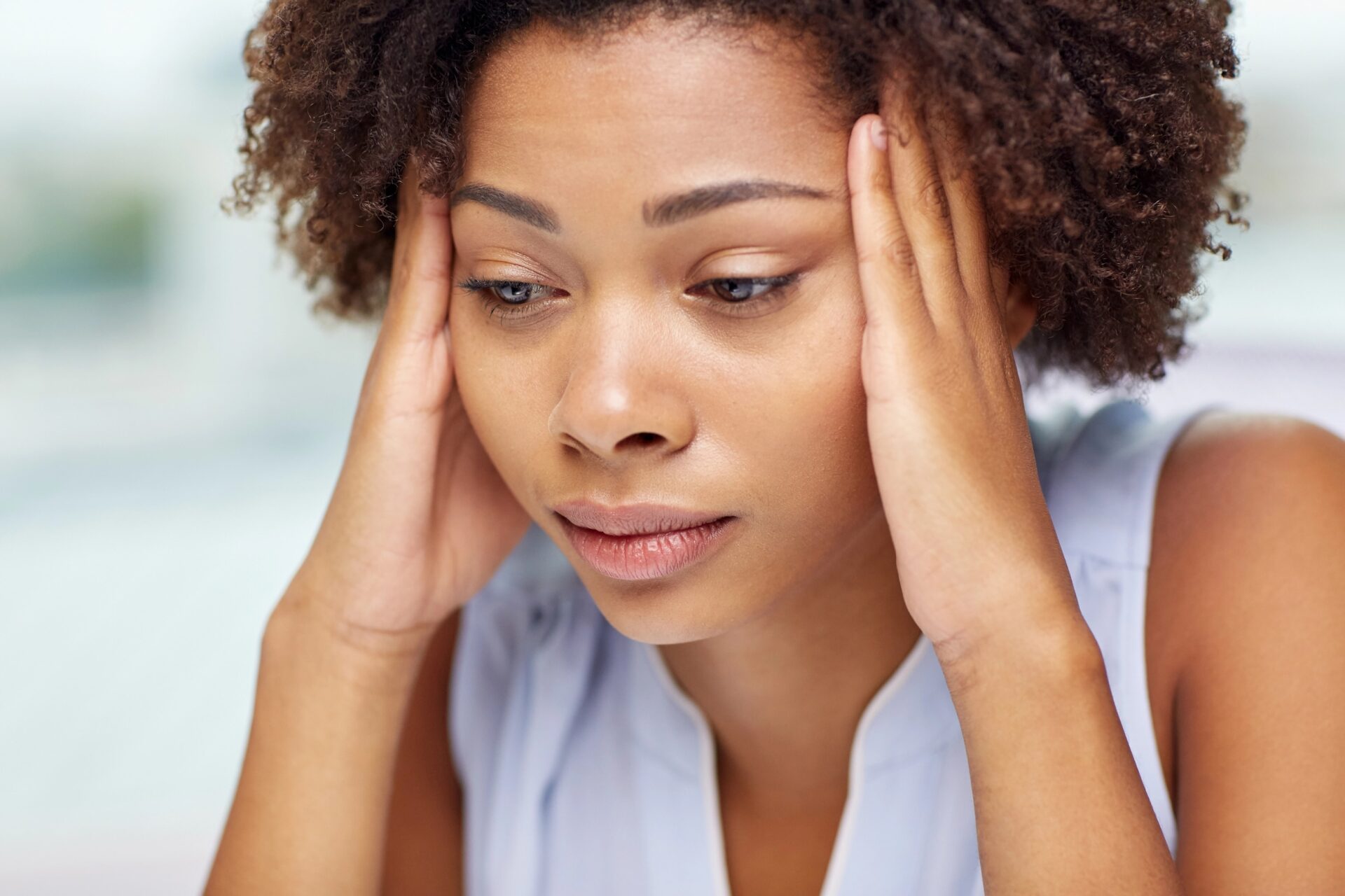 Stressful woman holding her head, feeling overwhelmed or anxious.