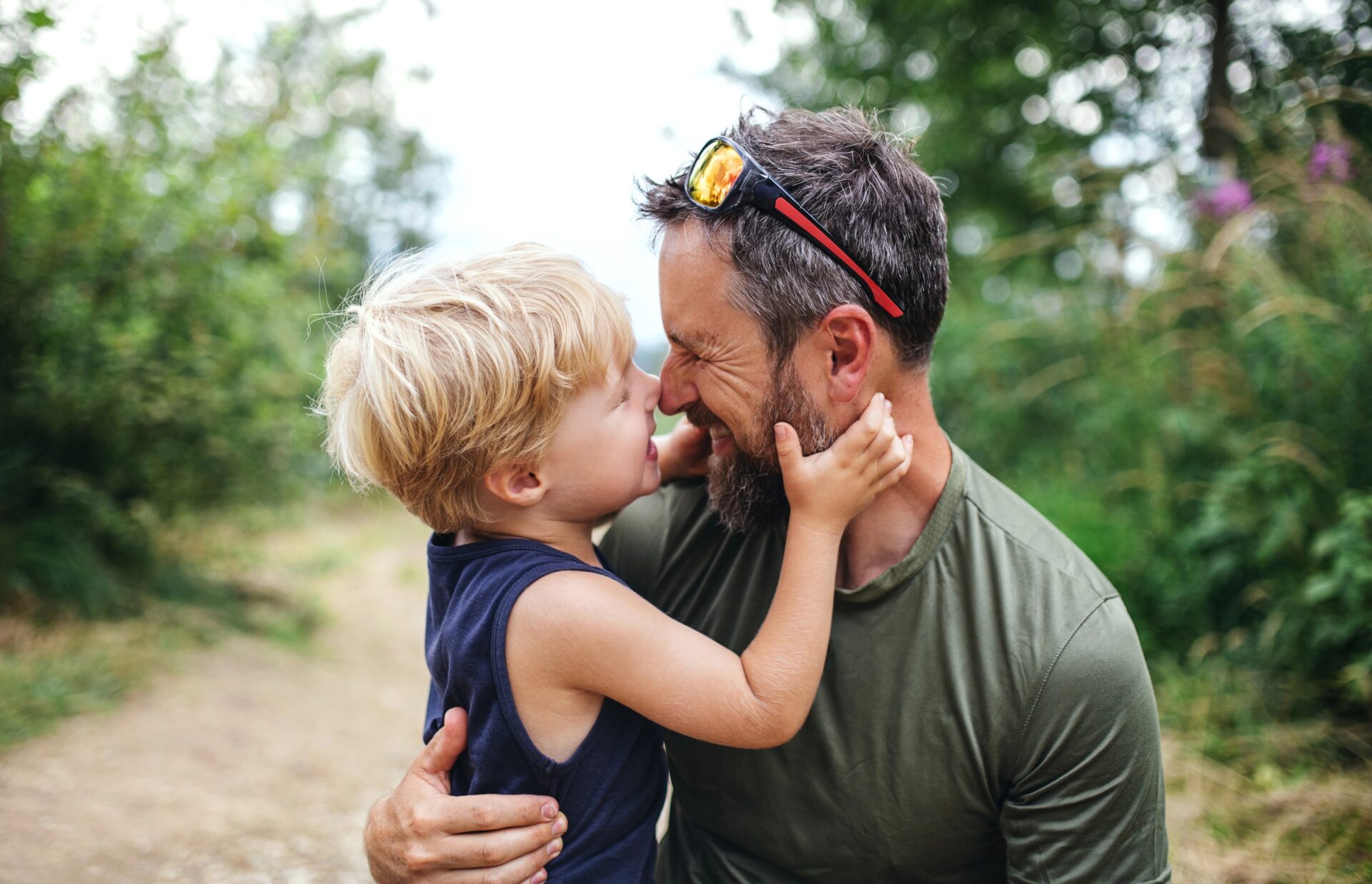 Father and young son sharing a tender moment outdoors.