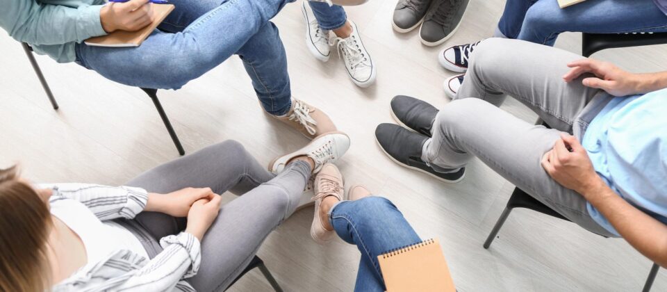 Support group therapy session with diverse participants sharing experiences and insights.